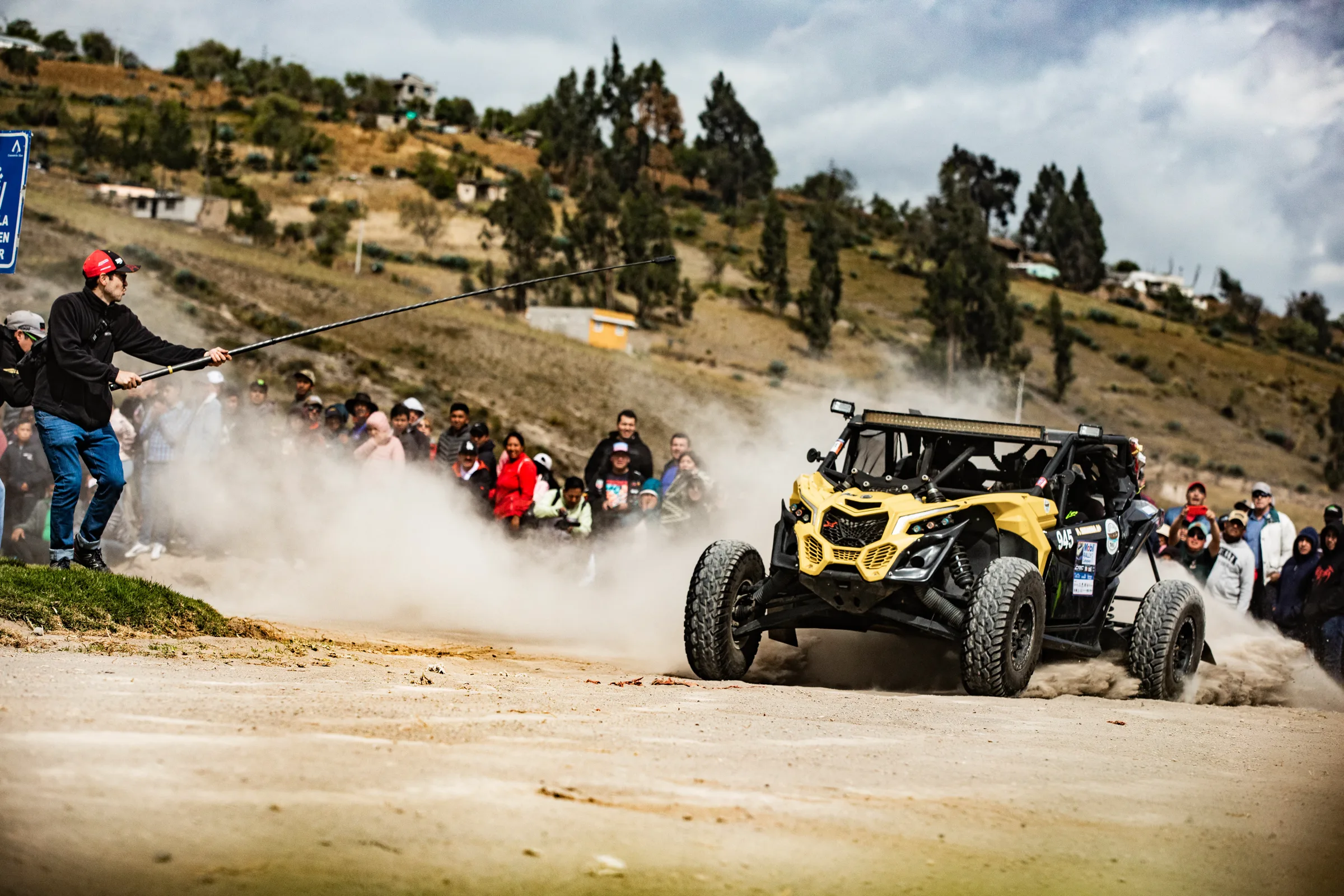 Daniel Espinoza graba con una cámara 360 en una pértiga el paso de un buggy de rally frente al público